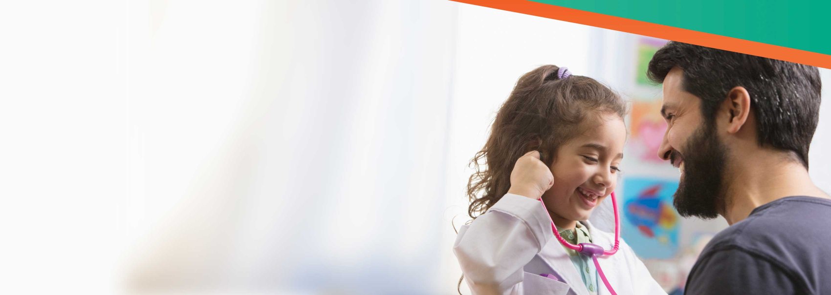 Young child playing with toy stethoscope laughing with pediatrician